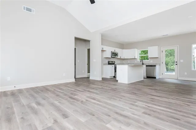 a kitchen with granite countertop white cabinets and stainless steel appliances