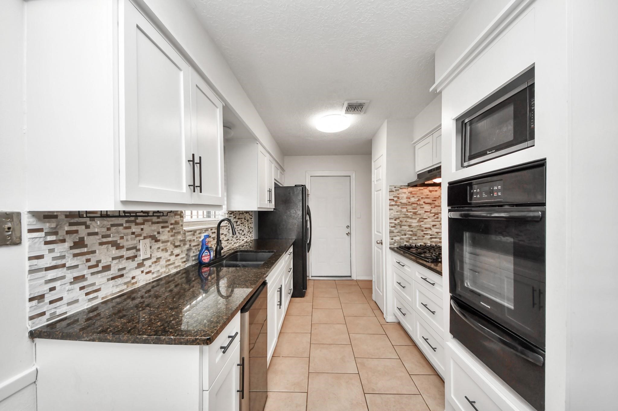 1415 Parry-Sound Pasadena, TX 77504 - Photo 13 of 34 a kitchen with granite countertop a sink and a stove top oven