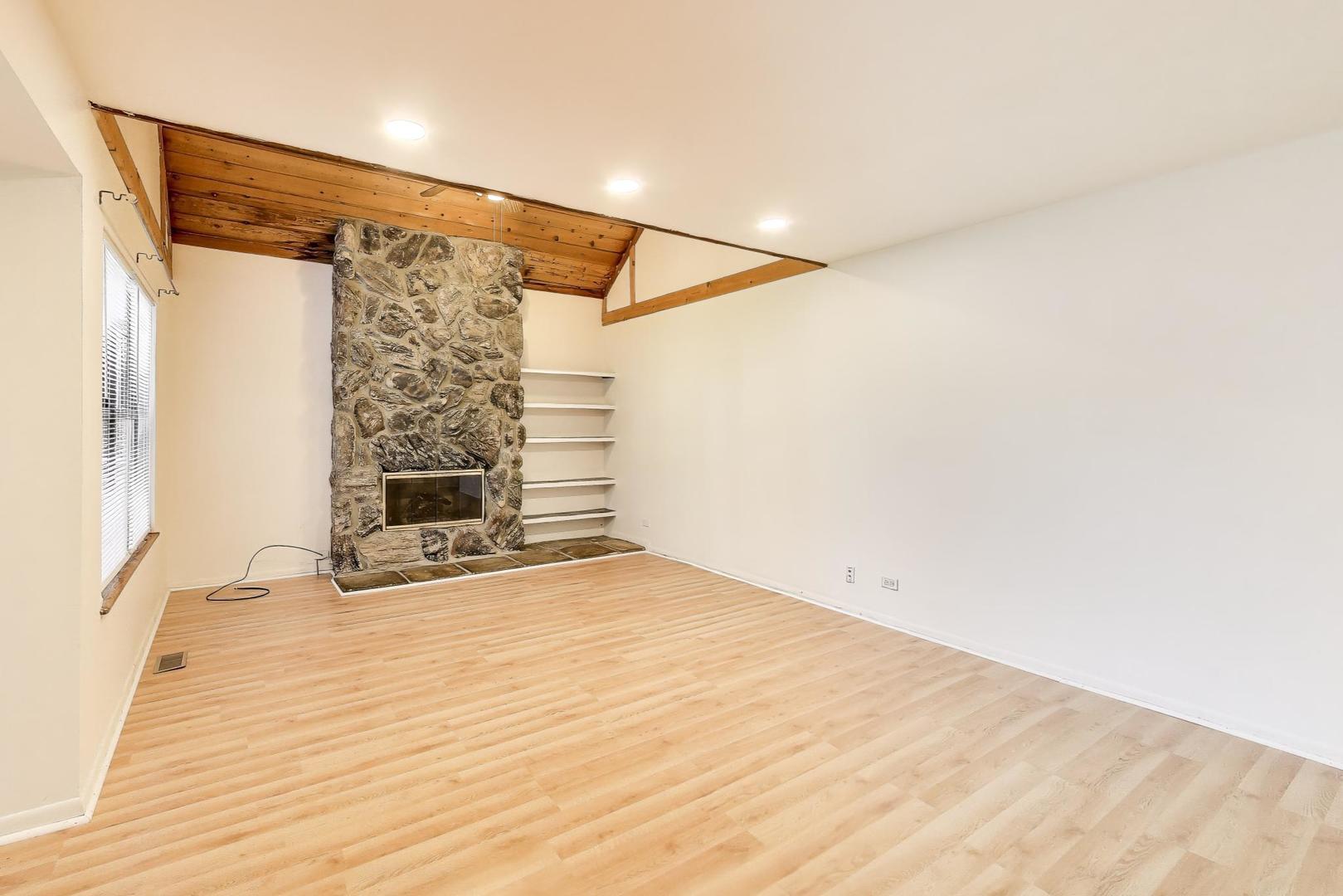 691 Wakefield Road, Unit 691 Gurnee, IL 60031 - Photo 5 of 26 a view of an empty room with wooden floor and a window