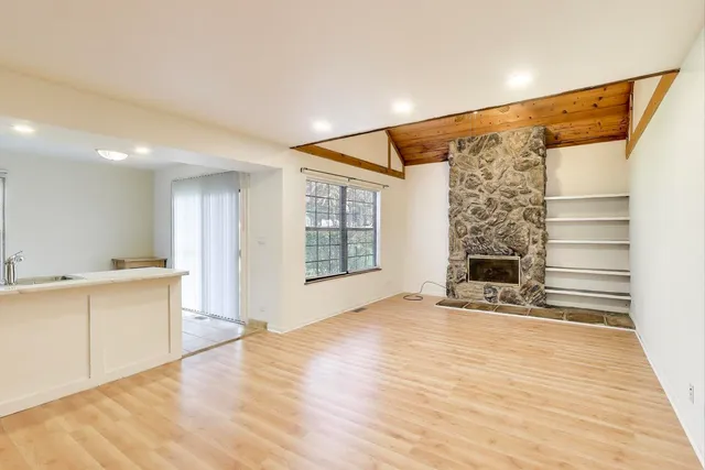a view of an empty room with window and wooden floor