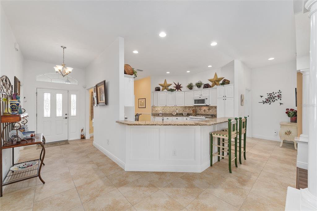 2053 Beecher Path The Villages, FL 32162 - Photo 17 of 44 a view of living room kitchen with stainless steel appliances wooden floor dining table and chairs