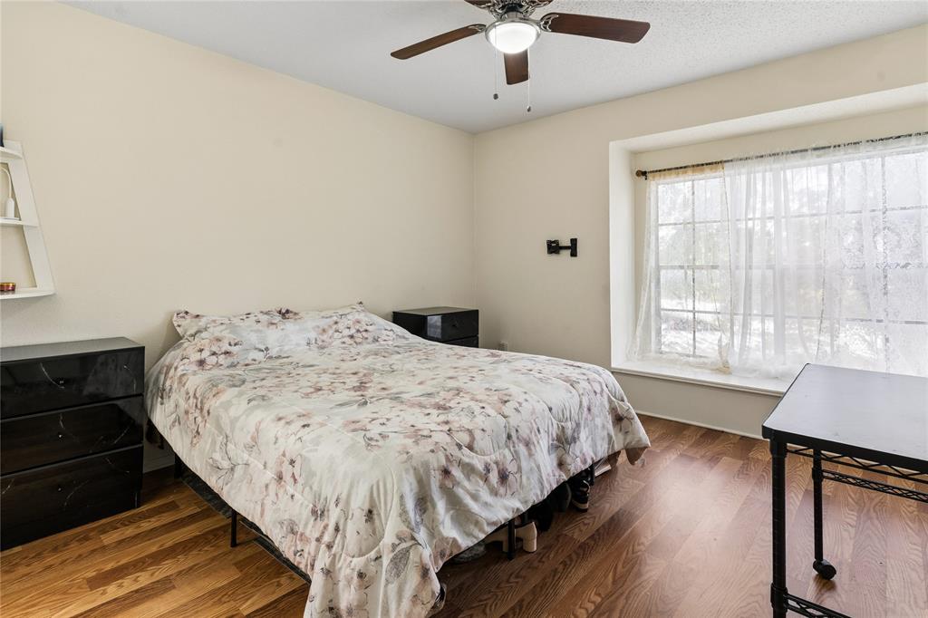 11311 Audelia Road, Unit 102 Dallas, TX 75243 - Photo 16 of 31 Wood-finish flooring, ceiling fan with integrated lighting, and a large window with deep sill