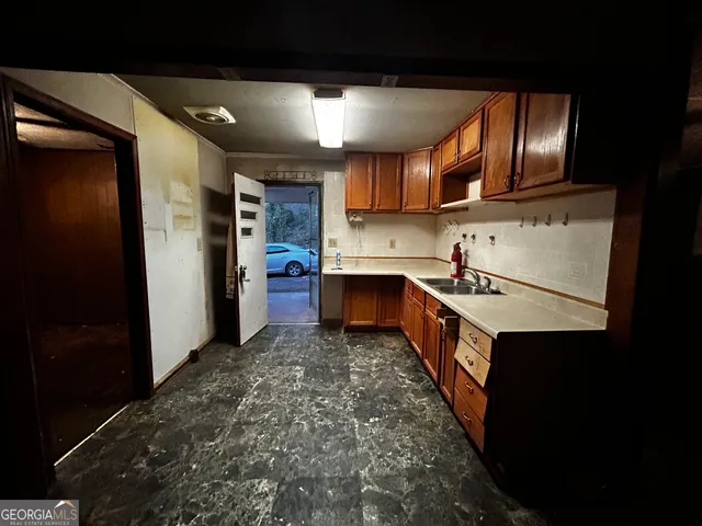 a kitchen with stainless steel appliances granite countertop a refrigerator a sink and a stove