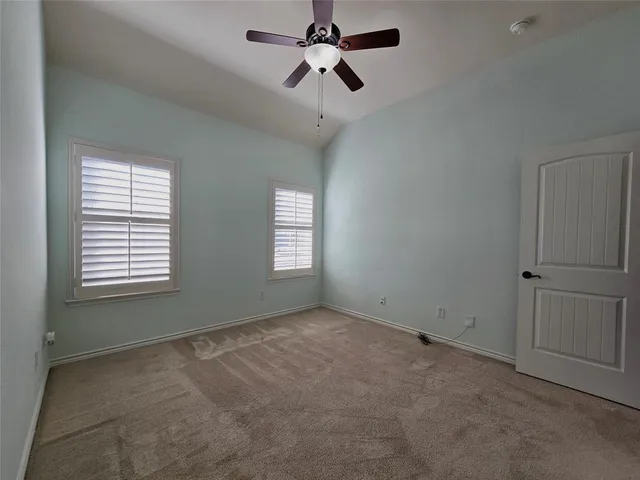 an empty room with windows and fan