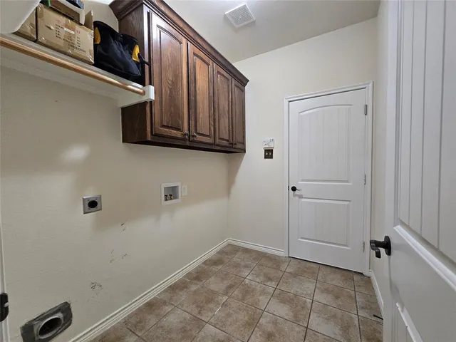 a view of a utility room with cabinets