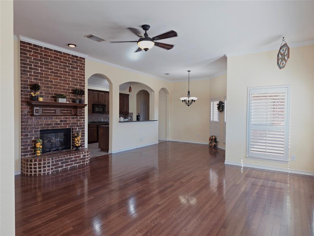 1800 Lancaster Gate Allen, TX 75013 - Photo 3 of 20 an empty room with wooden floor a ceiling fan a fireplace and windows