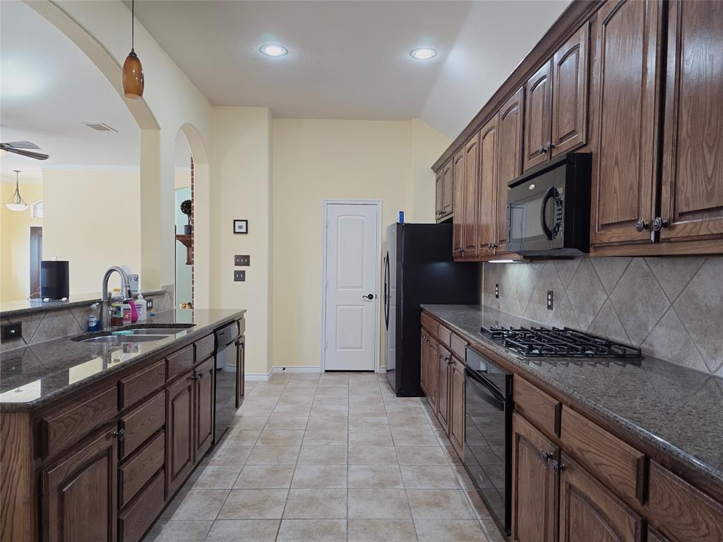 1800 Lancaster Gate Allen, TX 75013 - Photo 6 of 20 a kitchen with stainless steel appliances granite countertop a stove a sink dishwasher a refrigerator and a microwave