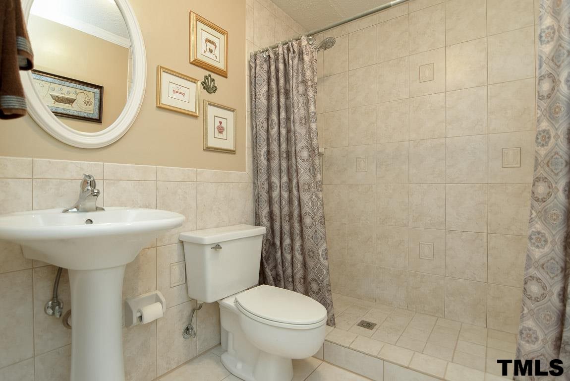 8101 Winstone Court Raleigh, NC 27615 - Photo 19 of 25 Pedestal sink and tile surround shower.