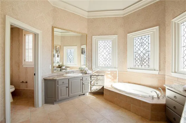 an empty room with wooden floor chandelier fan and windows