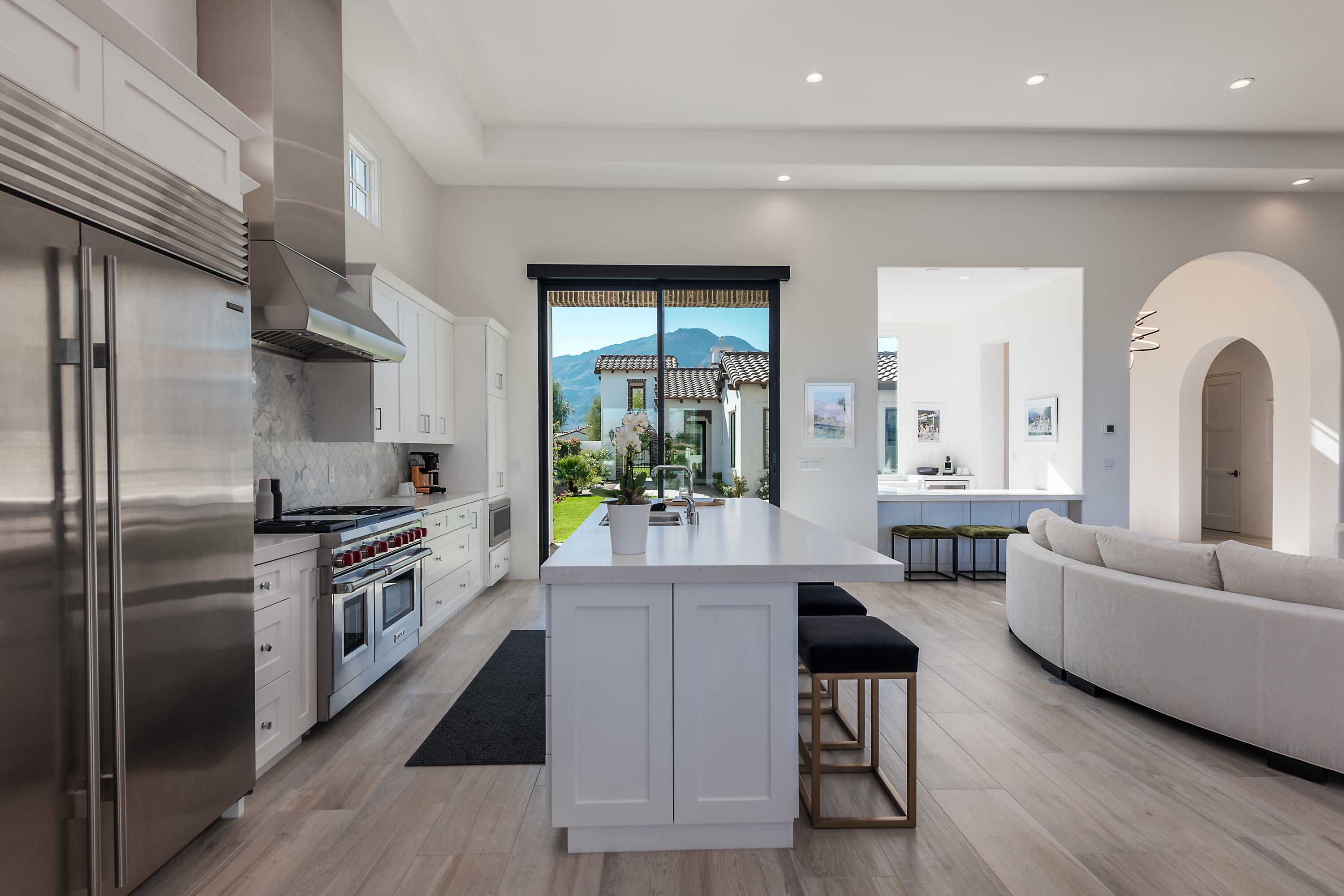 81660 Andalusia La Quinta, CA 92253 - Photo 19 of 36 a kitchen with stainless steel appliances granite countertop a refrigerator a stove a sink and a dining table with wooden floor