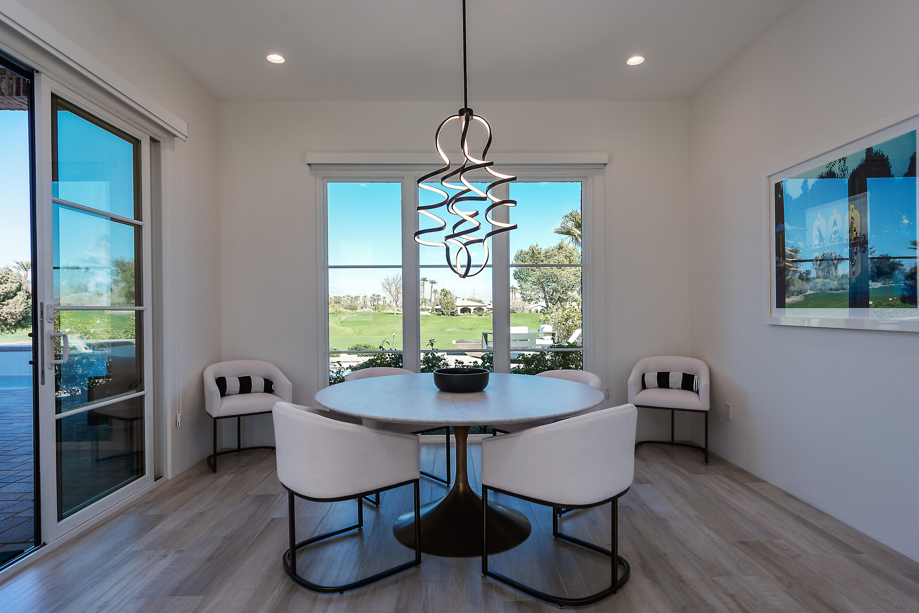 81660 Andalusia La Quinta, CA 92253 - Photo 20 of 36 a dining room with furniture a chandelier and wooden floor