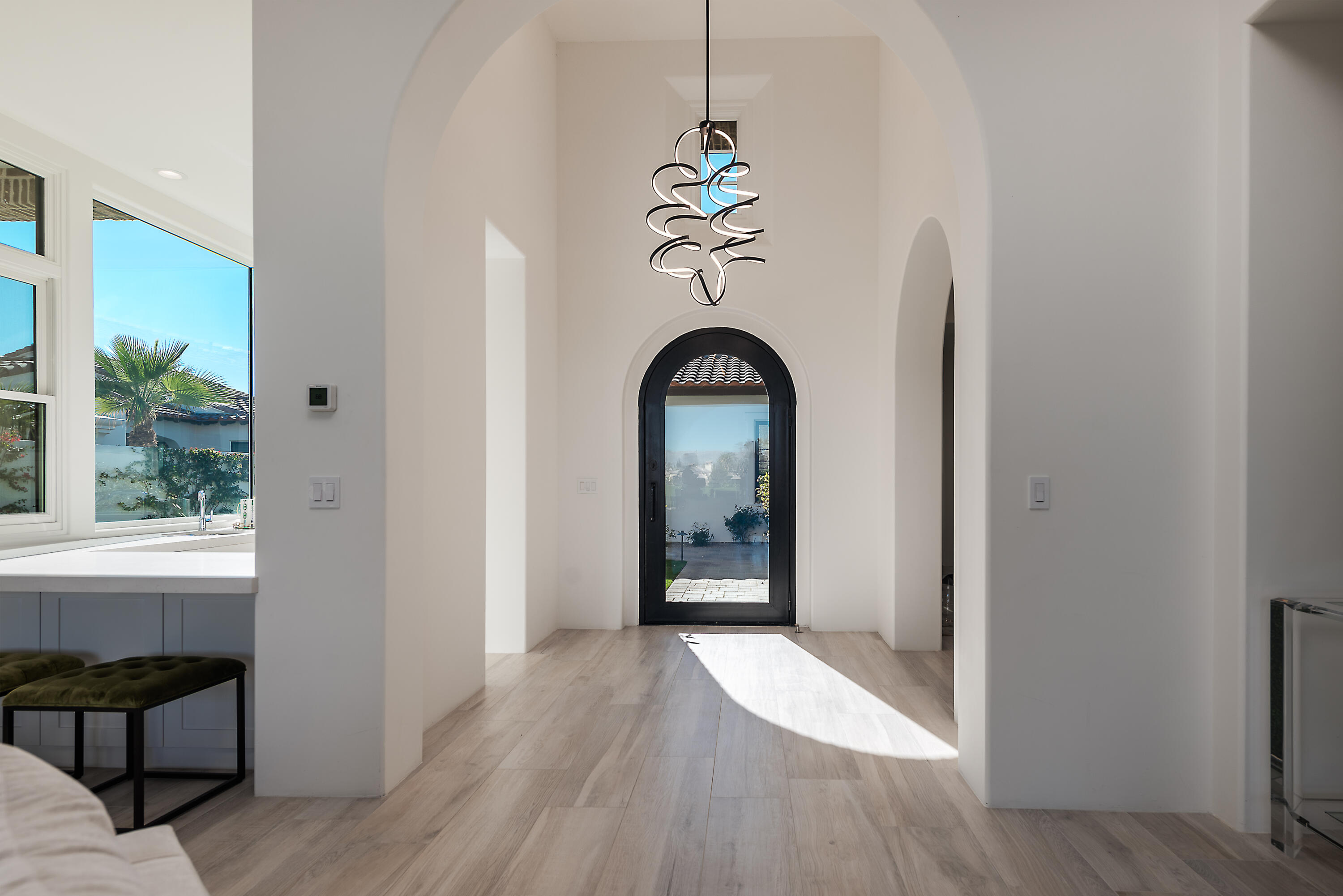 81660 Andalusia La Quinta, CA 92253 - Photo 7 of 36 a view of a hallway with wooden floor and a chandelier