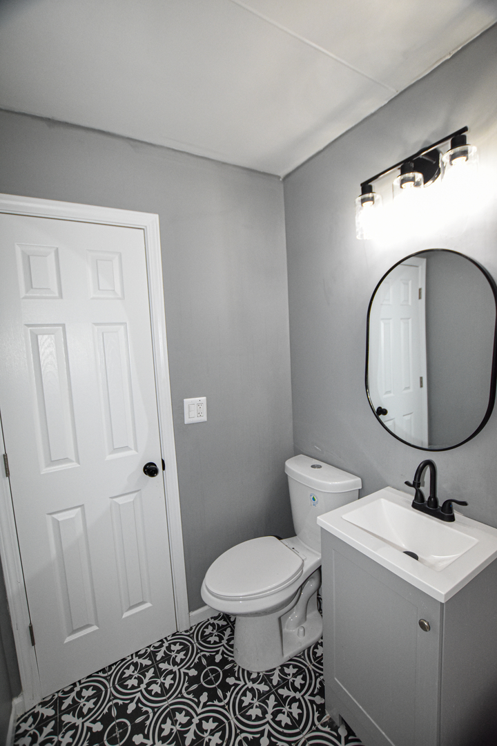 109 South Bartlett Road Streamwood, IL 60107 - Photo 31 of 39 a bathroom with a toilet a sink and a mirror