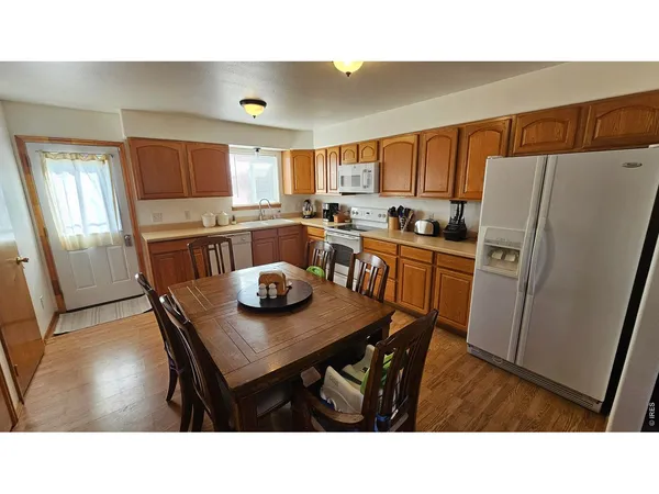 a kitchen with a table chairs and refrigerator