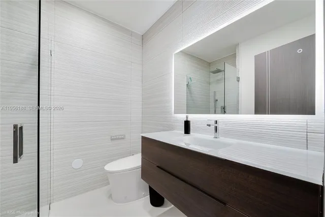 a bathroom with a double vanity sink toilet and shower