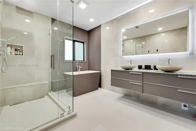 a bathroom with a tub a sink and mirror