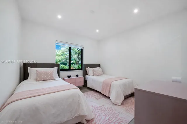 a bedroom with two beds and a night stand