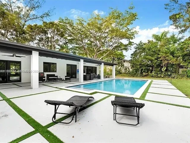 a swimming pool with outdoor seating and yard