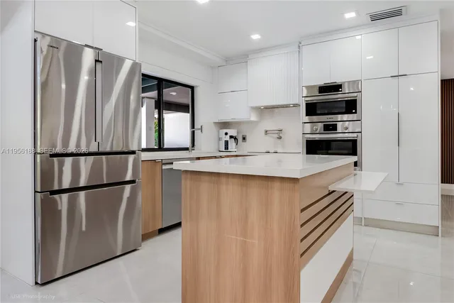 a kitchen with stainless steel appliances granite countertop a refrigerator a sink and a stove