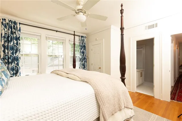a spacious bedroom with a large bed and a chandelier