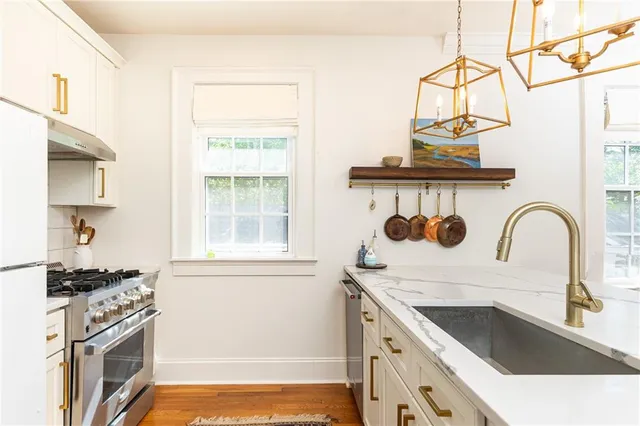 a kitchen with a stove and a white wooden cabinets