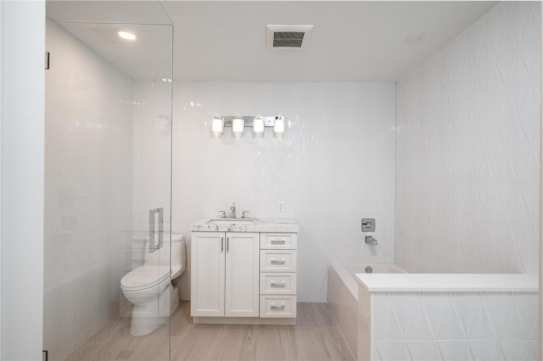 13731 Stirling Road Southwest Ranches, FL 33330 - Photo 54 of 55 a bathroom with a toilet a sink a tub and mirror