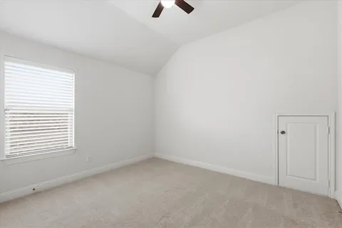 an empty room with a window and a ceiling fan