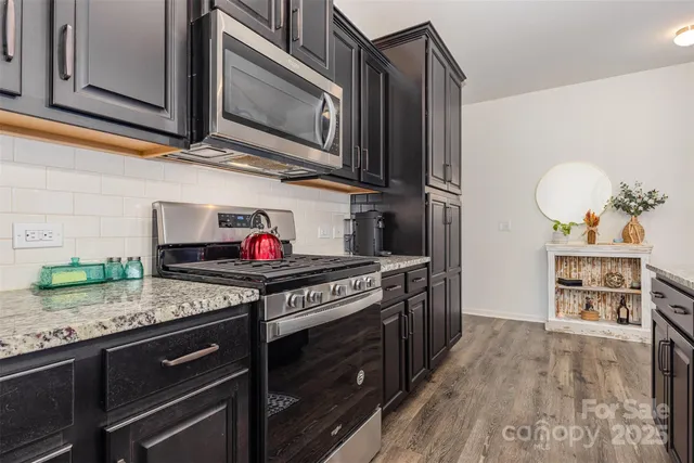 a kitchen with stainless steel appliances granite countertop a stove and a microwave