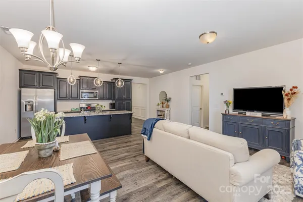 a living room with kitchen island furniture and a flat screen tv