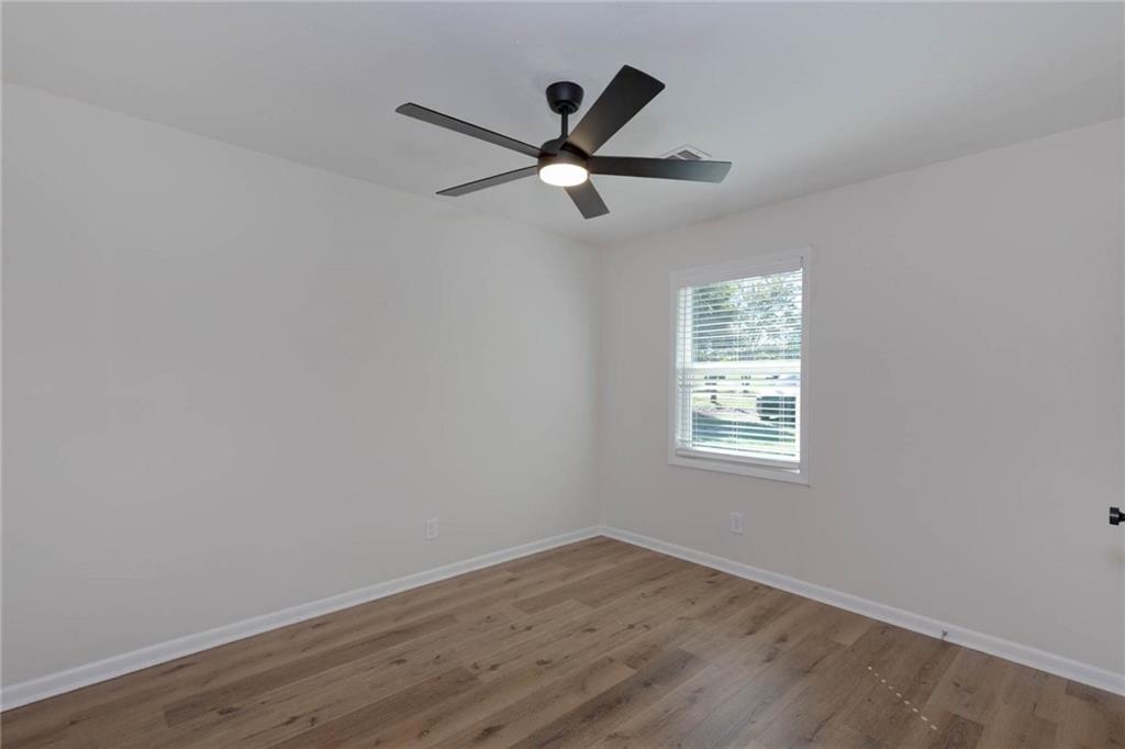 2899 Lamb Road Smiths Station, AL 36877 - Photo 20 of 26 Recessed window with blinds, wood-finish flooring, and a ceiling fan with integrated lighting
