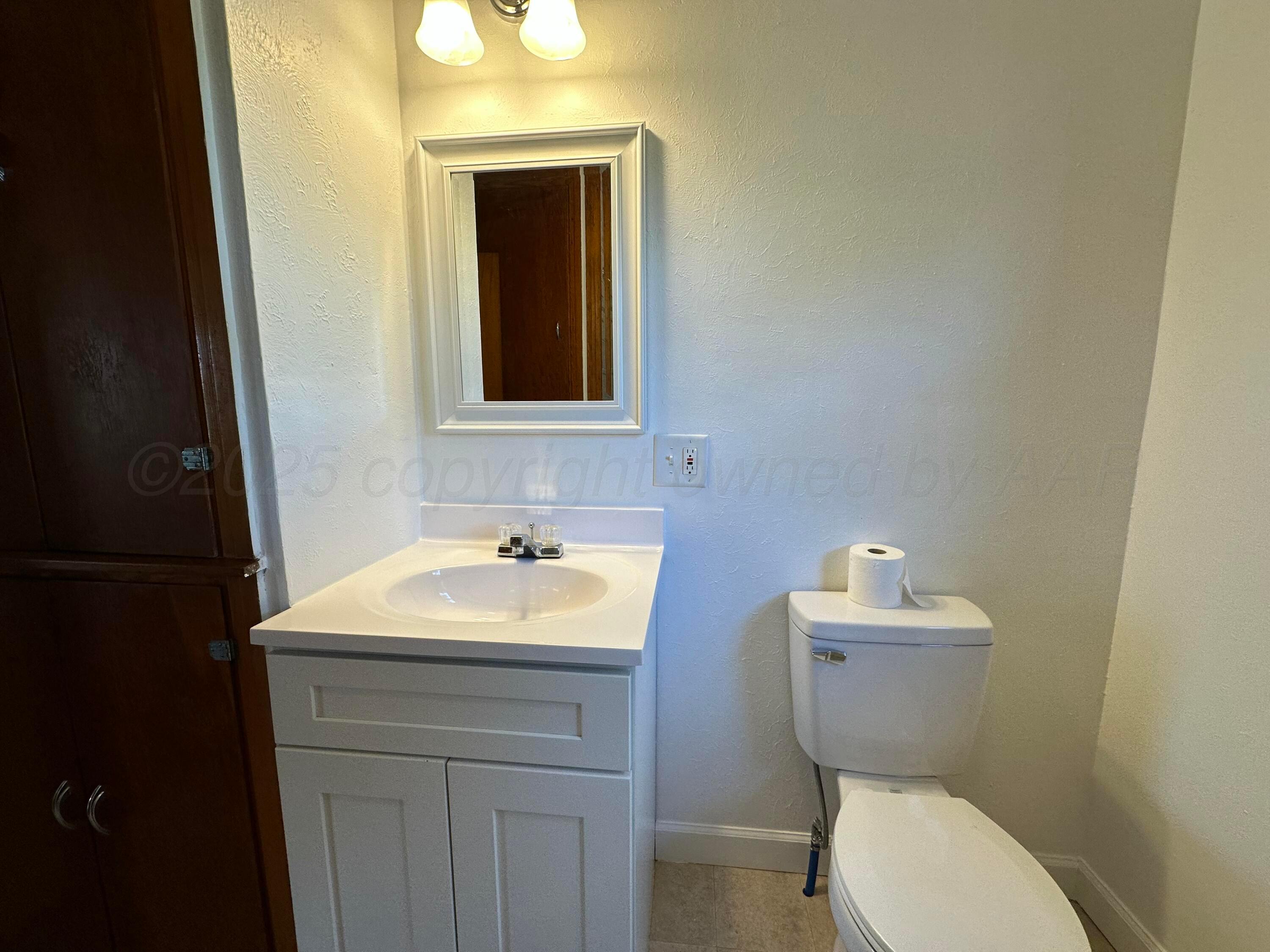 913 Bell Avenue Turkey, TX 79261 - Photo 12 of 18 a bathroom with a toilet sink and mirror