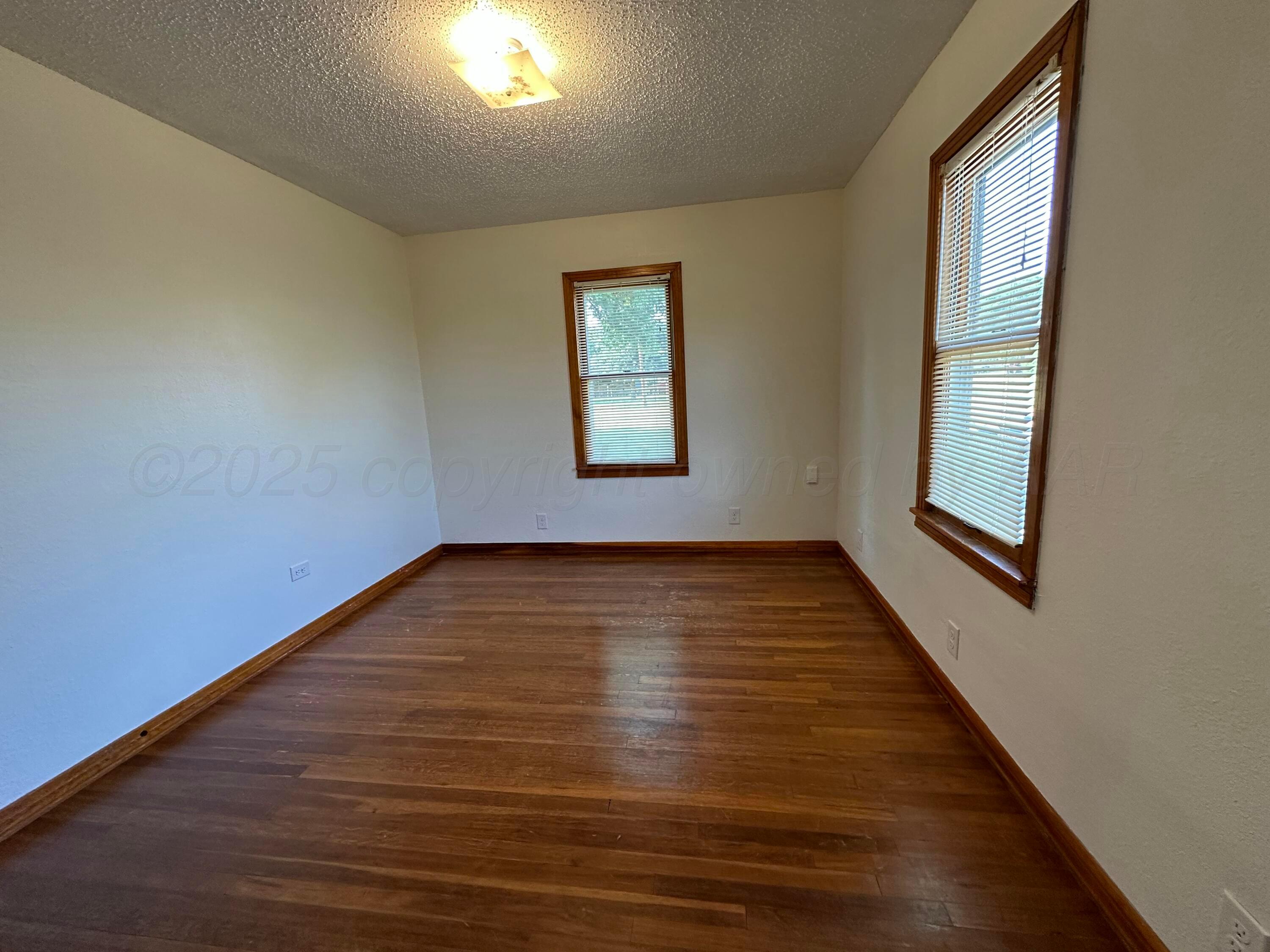 913 Bell Avenue Turkey, TX 79261 - Photo 14 of 18 a view of empty room with wooden floor and fan