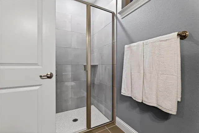an empty room with wooden floor chandelier fan and windows