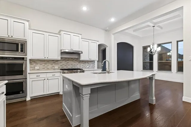 a kitchen with stainless steel appliances granite countertop a sink stove and microwave