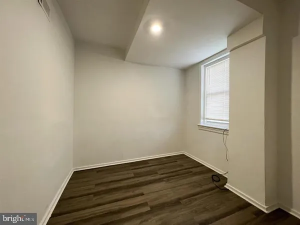 a room with wooden floor and windows