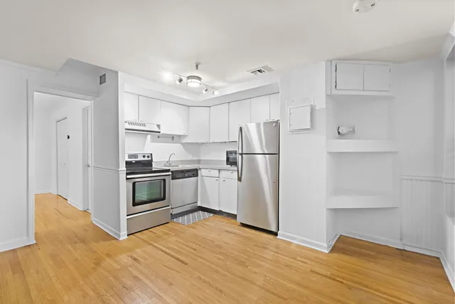 a kitchen with stainless steel appliances a refrigerator sink and cabinets