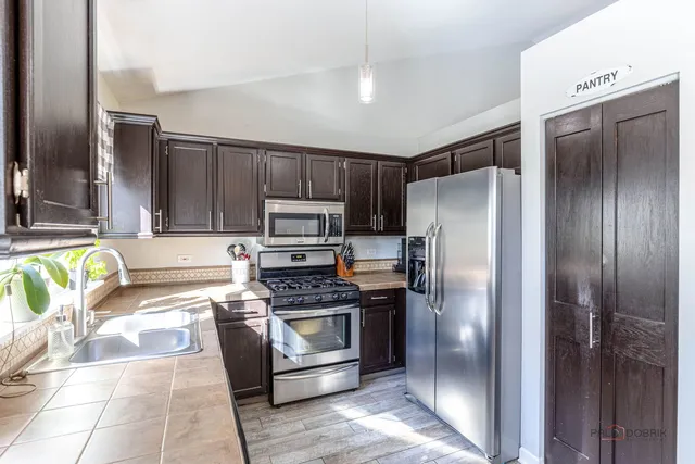 a kitchen with granite countertop a refrigerator and a stove top oven