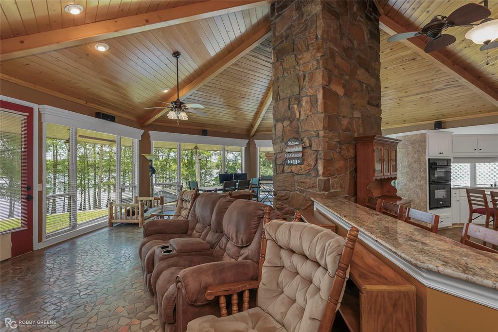 10865 Ferry Lake Road Oil City, LA 71061 - Photo 13 of 36 Living area featuring ceiling fan, a wood ceiling with exposed beams, dark stone finish flooring, recessed lighting, and high vaulted ceiling