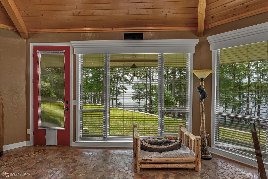 10865 Ferry Lake Road Oil City, LA 71061 - Photo 20 of 36 Entryway featuring healthy amount of natural light, wood ceiling, and stone finish floors