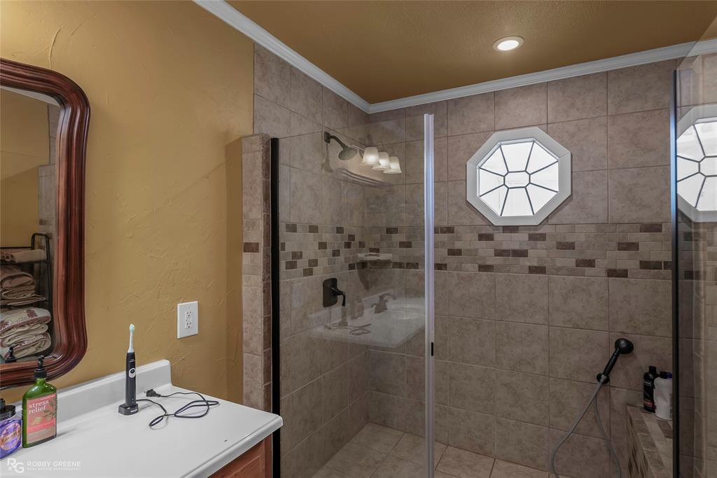 10865 Ferry Lake Road Oil City, LA 71061 - Photo 30 of 36 Bathroom featuring crown molding, a stall shower, recessed lighting, and vanity