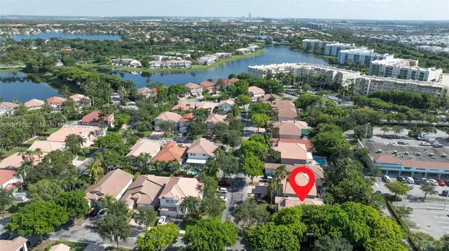 an aerial view of a house with a yard and large trees