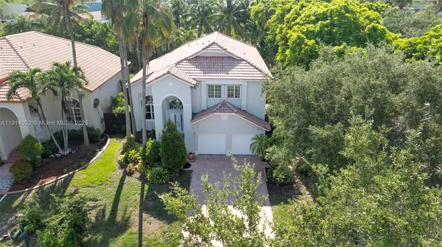 a view of a white house with a yard and plants