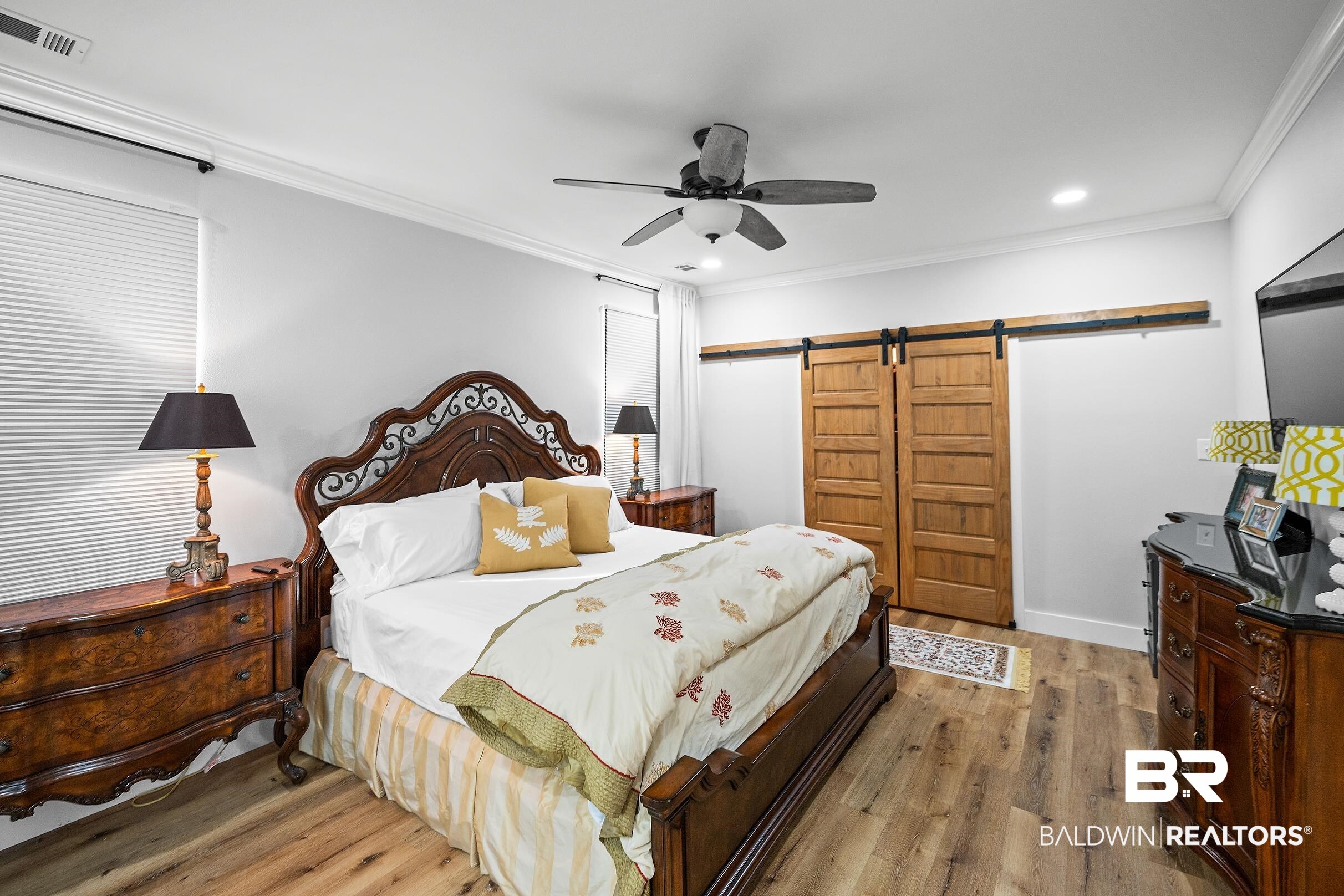 8490 Bay View Drive Foley, AL 36535 - Photo 58 of 67 Bedroom with a barn door, wood finished floors, ornamental molding, a ceiling fan, and recessed lighting