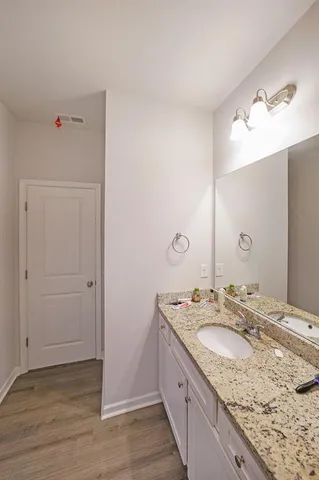 a bathroom with a granite countertop sink and a mirror