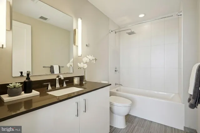 a bathroom with a granite countertop sink toilet and shower