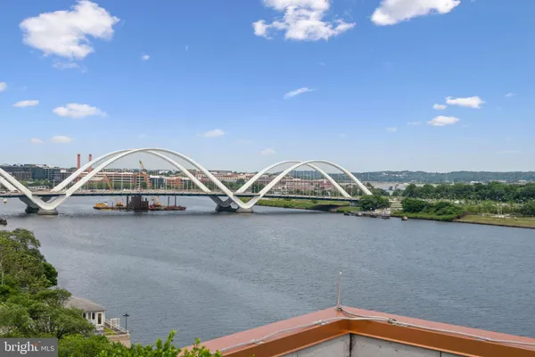 an empty room with wooden floor and windows with curtains