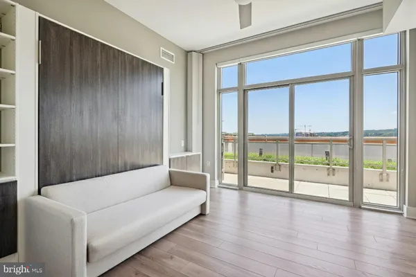 a living room with furniture a large window with kitchen view