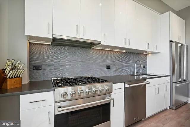 a kitchen with white cabinets and a stove top oven