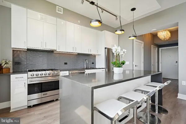 a kitchen with kitchen island a counter top space a sink stainless steel appliances and cabinets