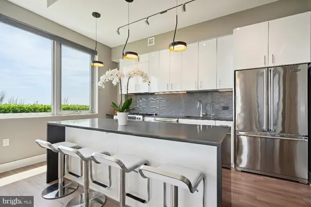 a kitchen with kitchen island a counter top space a sink stainless steel appliances and cabinets